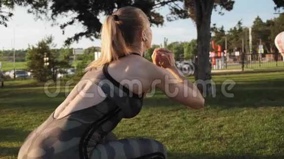 穿着卡其裤的女性运动屁股在公园慢动作蹲视频的预览图