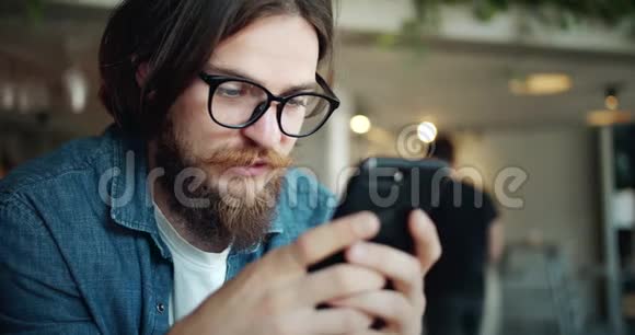 男性浏览智能手机在咖啡厅特写视频的预览图