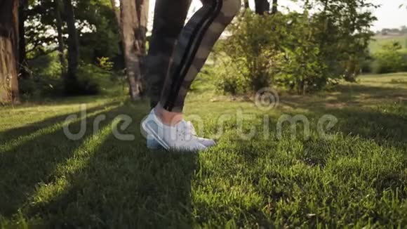 近距离观看穿白色运动鞋的女性双脚在公园慢动作视频的预览图