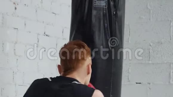 激烈的拳击手强化训练他练习用冲孔袋冲孔视频的预览图