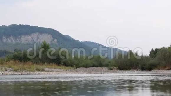 山河的水流它平静地在山谷中流动洛基海岸是可见的在地平线上群山覆盖着视频的预览图