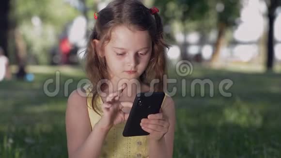 公园里的女孩用智能手机与社交网络中的朋友交流微笑少年用手机聊天打字视频的预览图