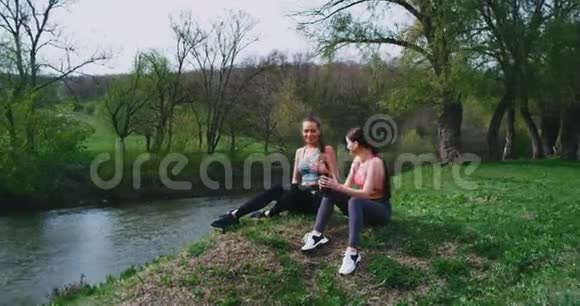 在美丽的自然景观中两位参加运动的女士休息一下口渴喝点水视频的预览图