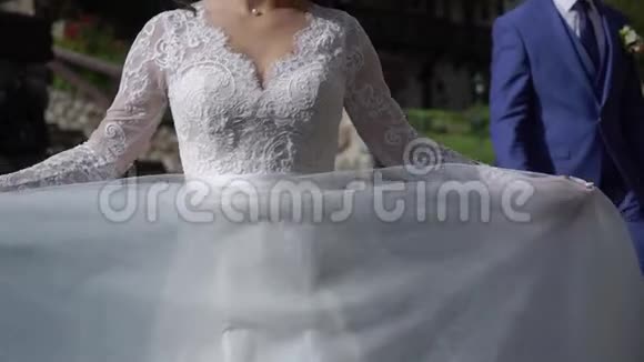 穿着婚纱的年轻新娘在公园里盘旋白色豪华礼服视频的预览图