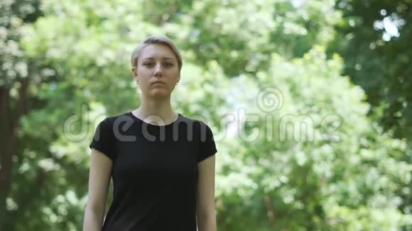 漂亮的金发女人把食指放在她的嘴唇前在一个公园在斯洛文尼亚视频的预览图