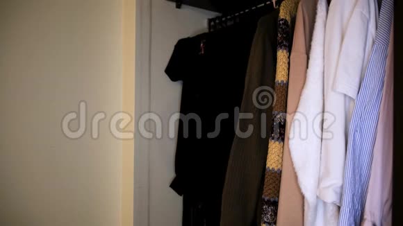 白色墙壁附近衣柜里衣服的特写镜头概念全衣柜内不同衬衫的侧视图视频的预览图