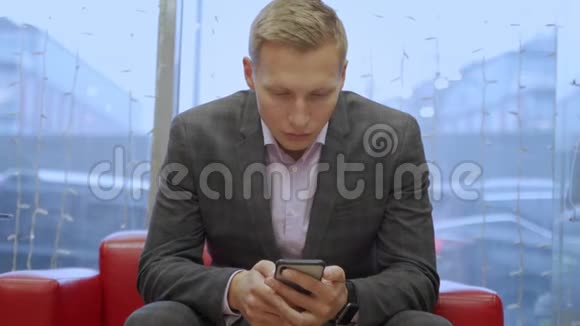 一位年轻英俊的商人用他的电话视频的预览图