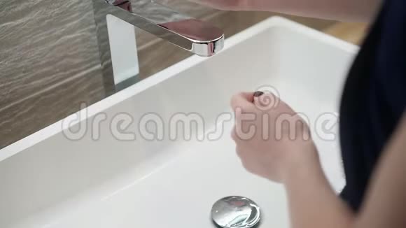 女人在浴室里用自来水洗手卫生概念从肩膀看4k视频的预览图
