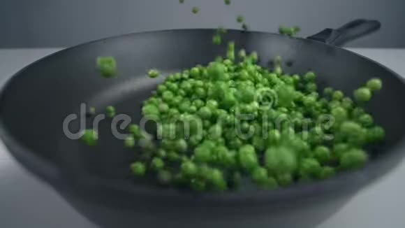 豌豆被缓慢地抛到平底锅里新鲜蔬菜在240英尺的范围内下降烹饪蔬菜混合物视频的预览图