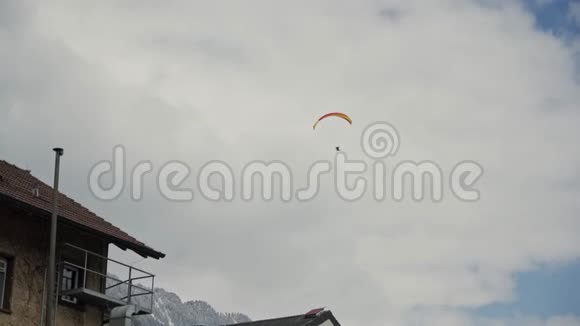 带着彩色黄红色降落伞的跳伞者在阴天的身影视频的预览图