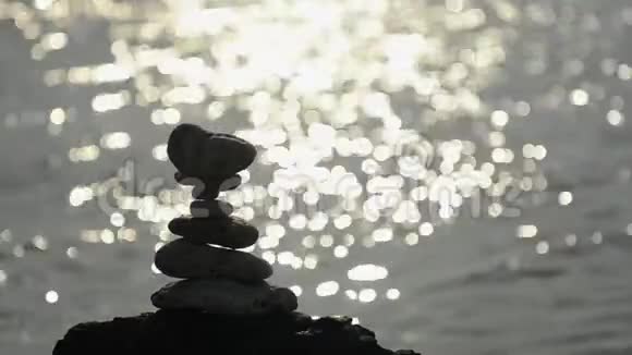 瓦片岩石轮廓太阳在水后闪耀视频的预览图