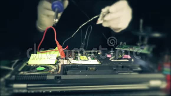修理工将连接器焊接到电脑电路板上把烙铁和一块锡放在烟雾中视频的预览图