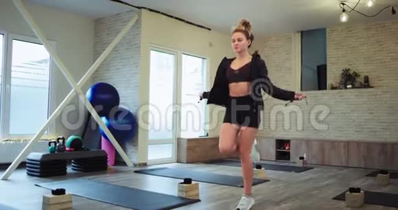 时尚的运动女性肌肉发达在一个宽敞的有氧健身室里她的身体在一根绳子上跳跃非常集中在一个视频的预览图