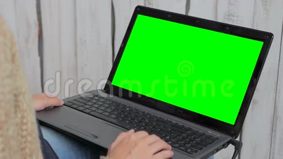 女人用绿色屏幕的笔记本电脑视频的预览图
