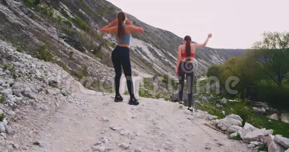 在大山旁的夏日里两位身材完美的女士在屋顶上奔跑视频的预览图