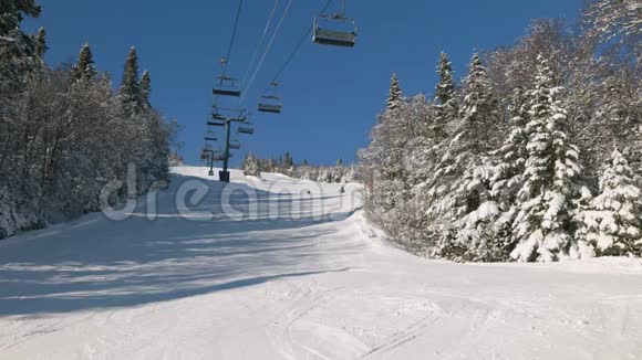 滑雪缆车上滑雪者的视野滑雪斜坡上有雪覆盖的山椅视频的预览图