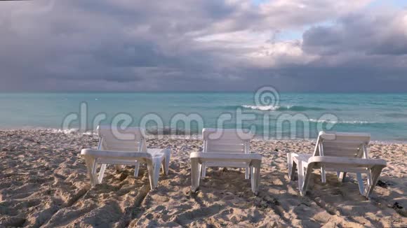 三张海边椅子前面有戏剧性的天空云视频的预览图