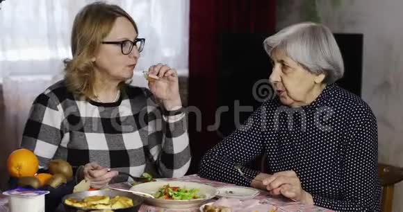 两个老女人在餐桌边聊天吃饭视频的预览图