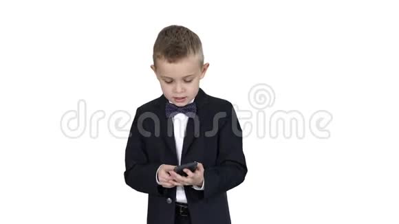 穿着服装走路和在白色背景上使用智能手机的小男孩视频的预览图