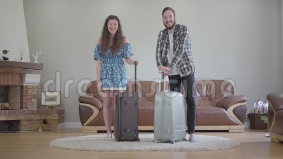 快乐的一对夫妇站在家里手里拿着大箱子年轻的胡须男和年轻漂亮的女孩准备好了视频的预览图