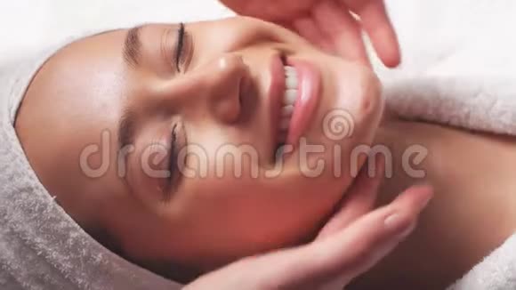 水疗女人面部按摩女性在美容水疗中心享受放松的面部按摩视频的预览图