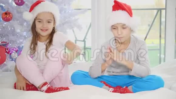 有趣的视频小兄弟姐妹在家里的卧室练习瑜伽在圣诞节的时候视频的预览图