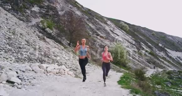 在美丽的夏日里充满魅力和激情的女士们在山路上奔跑美丽的夏日视频的预览图