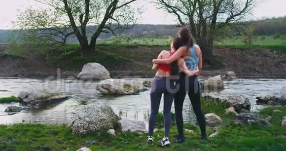 好朋友女士们在大自然的中央进行了艰苦的锻炼后她们欣赏着河的景色视频的预览图