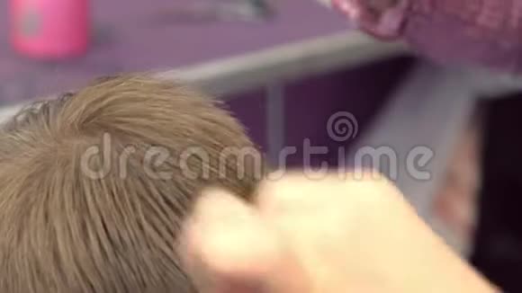 理发师用剪刀在男孩头上剪头发俯视图造型师手特写视频的预览图