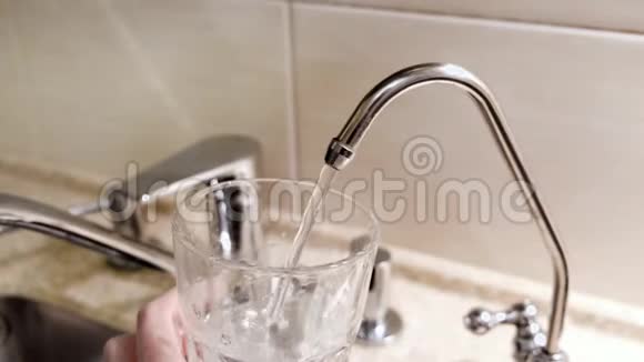 水从厨房的水龙头倒入玻璃杯概念厨房里往杯子里倒自来水的特写镜头视频的预览图