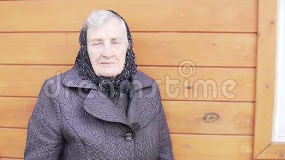 一个穿着灰色头发黑色围巾的老女人的特写视频的预览图