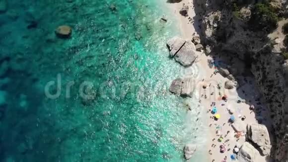 萨迪尼亚岛意大利奥罗西海岸美丽的海滩充满海滩遮阳伞和人们日光浴和游泳视频的预览图