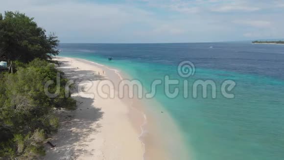热带岛屿海岸线上绿松石清澈的海水白色沙滩和绿色植物的海滩鸟瞰图视频的预览图