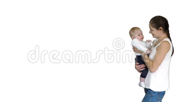 年轻的母亲手里拿着孩子走在白色的背景上视频的预览图