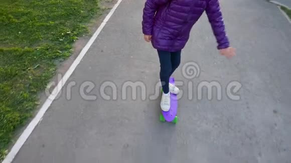 年轻的滑冰女孩骑在滑板上的城市慢动作从上面看少女喜欢玩滑板视频的预览图