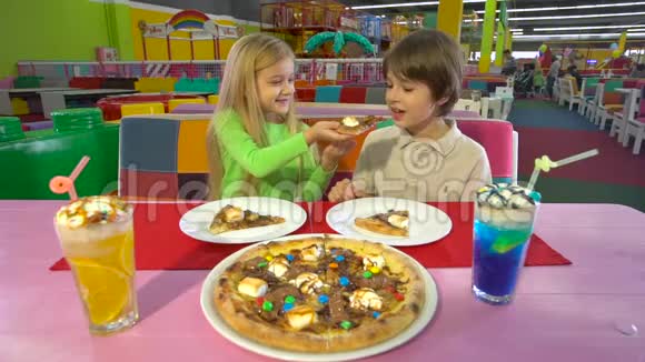快乐的朋友在儿童咖啡馆吃巧克力披萨晚餐视频的预览图