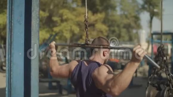 健身男在户外进行拉床训练视频的预览图