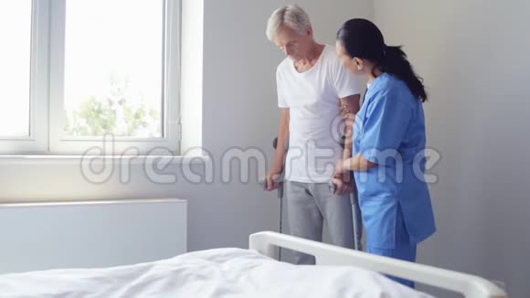 积极的护士帮助老人拄着拐杖走路视频的预览图