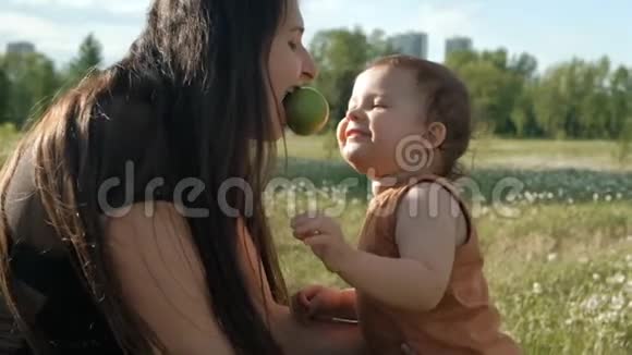 一位年轻的母亲和她的儿子吃苹果小孩子咬苹果视频的预览图