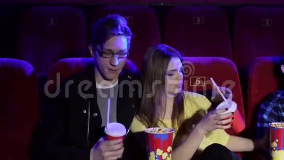 一对夫妇在看一部情节剧吃爆米花喝可乐视频的预览图