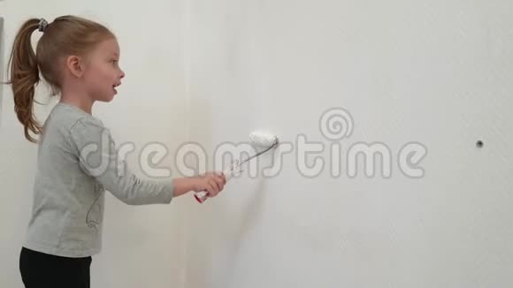 一个小女孩用白色油漆粉刷墙壁并帮助她的父母修理房子视频的预览图