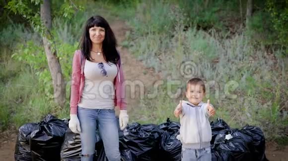 母亲向儿子展示她的榜样清理森林里的垃圾是很重要的环境教育视频的预览图
