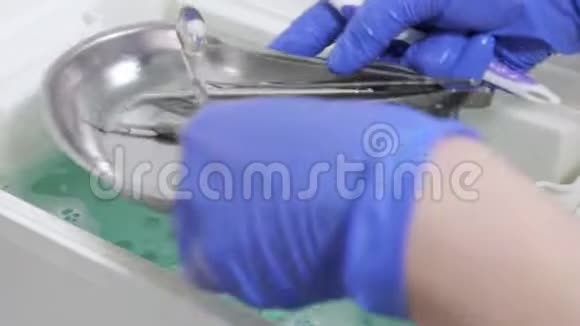 护士的手正在用消毒液清洗牙科器械和金属托盘视频的预览图