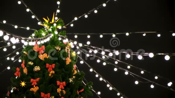 夜晚街道上装饰着玩具和花环的美丽圣诞树顶部的底部景色概念视频的预览图