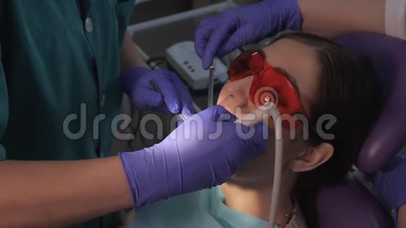 牙医正在用电牙刷照顾病人牙齿女人牙椅上的肖像视频的预览图