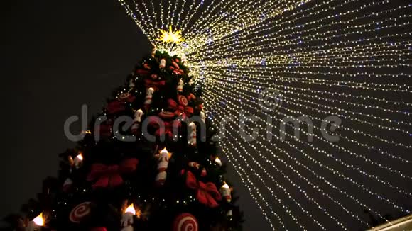 绿色圣诞树顶部的底部视图夜空背景上有花环和装饰玩具概念新的视频的预览图