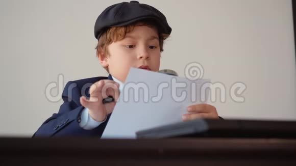 小男孩企业家坐在桌子旁的办公室里工作视频的预览图