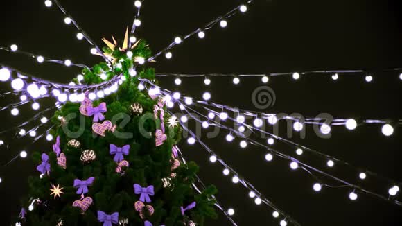 夜晚街道上装饰着玩具和花环的美丽圣诞树顶部的底部景色概念视频的预览图