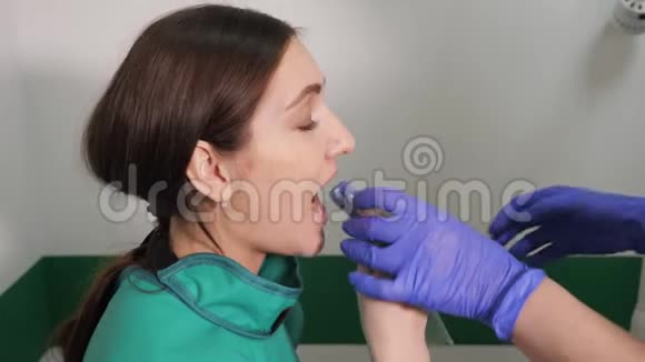 牙医在牙科诊所为年轻女性准备颌面X线图像视频的预览图