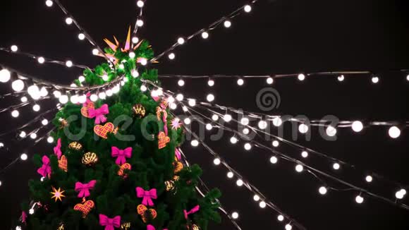 绿色圣诞树顶部的底部视图夜空背景上有花环和装饰玩具概念新的视频的预览图